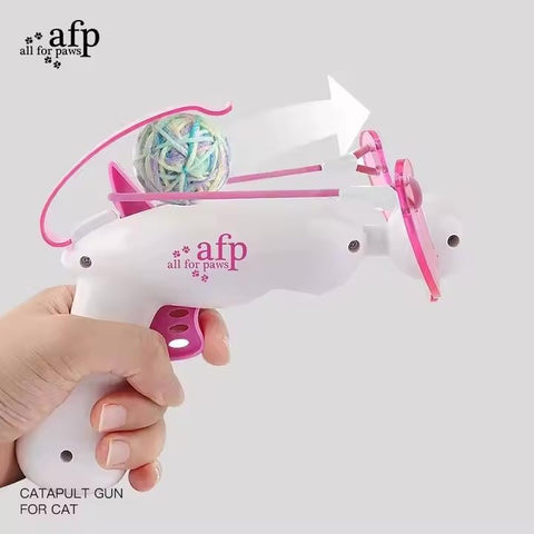 Cat playing with a launched yarn ball from a crossbow toy